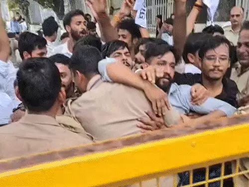 लखनऊ विश्वविद्यालय के गेट पर प्रदर्शन करते छात्र और तैनात पुलिस बल।