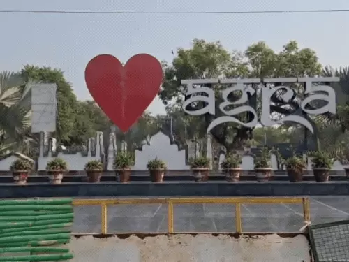 आगरा में साफ मौसम और तेज धूप के बीच सड़क पर आते-जाते लोग।