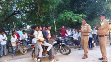 अम्बेडकरनगर के मंशापुर चौराहे पर पांच सवारी बैठी बाइक की जांच करती पुलिस।
