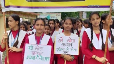 अंबेडकरनगर में सड़क सुरक्षा जागरूकता रैली निकालते स्कूली विद्यार्थी और प्रशासनिक अधिकारी।
