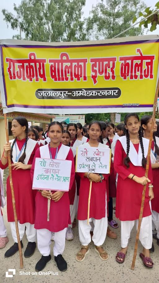 अंबेडकरनगर में सड़क सुरक्षा जागरूकता रैली निकालते स्कूली विद्यार्थी और प्रशासनिक अधिकारी।