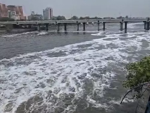 लखनऊ की गोमती नदी में बारिश के बाद प्रदूषण के कारण बनी सफेद झाग की परत का दृश्य।