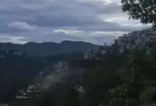 हिमाचल प्रदेश में बारिश के दौरान पहाड़ी सड़क और बादलों से घिरा मौसम।