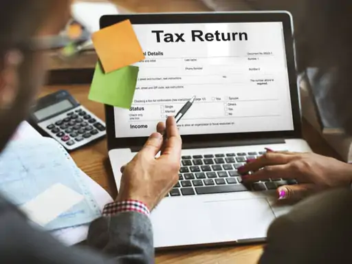 लैपटॉप पर इनकम टैक्स रिटर्न (ITR) फाइल करते हुए व्यक्ति की सांकेतिक तस्वीर।