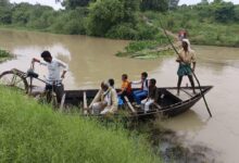अंबेडकरनगर में टौंस नदी का जलस्तर बढ़ने के बाद नाव से आवागमन करते ग्रामीण।