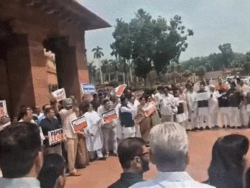 संसद भवन के बाहर प्रदर्शन करते NDA और विपक्षी सांसद, नारेबाजी के दौरान मौजूद सुरक्षाकर्मी।