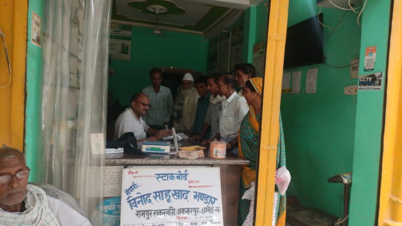 अंबेडकरनगर के खाद केंद्र पर ई-पॉस सर्वर खराब होने से इंतजार करते किसान।