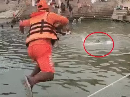 वाराणसी के दांडी घाट पर गंगा नदी में रेस्क्यू अभियान चलाकर युवक को बचाते NDRF के जवान।