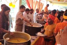 शिवबाबा धाम में कांवड़ियों को प्रसाद वितरित करते प्रशासनिक अधिकारी