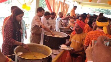 शिवबाबा धाम में कांवड़ियों को प्रसाद वितरित करते प्रशासनिक अधिकारी