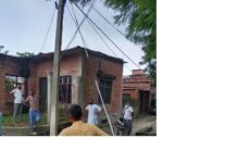 अंबेडकरनगर के बड़ागांव में बिजली के खंभे और स्टे वायर की जांच करते बिजली विभाग के कर्मचारी।