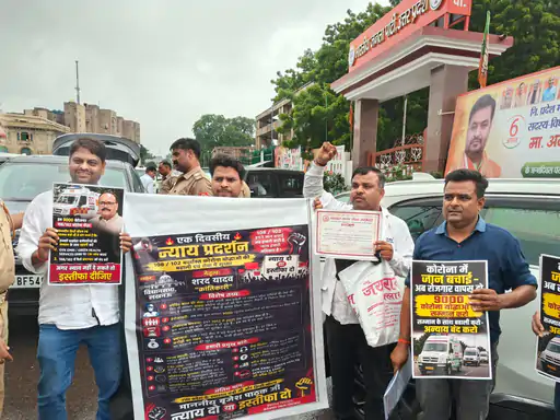 लखनऊ में भाजपा कार्यालय के बाहर तख्तियां लेकर प्रदर्शन करते डायल-108 और डायल-102 एंबुलेंस चालक।