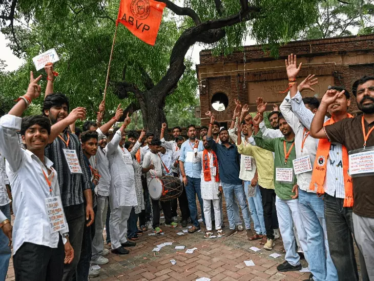 दिल्ली यूनिवर्सिटी छात्र संघ चुनाव के दौरान मतदान केंद्र पर वोट डालते छात्र।