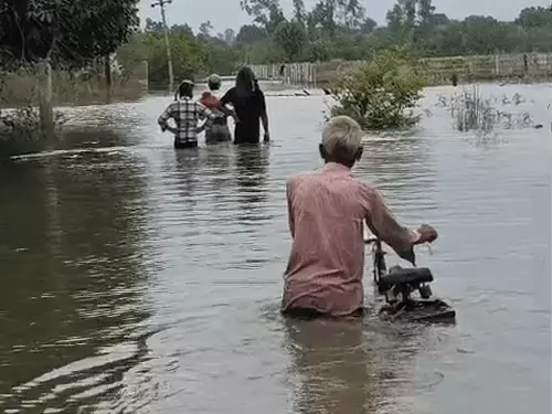 कानपुर कटरी के गांवों में बाढ़ के पानी के बीच नाव और ट्रैक्टर से निकलते ग्रामीण।