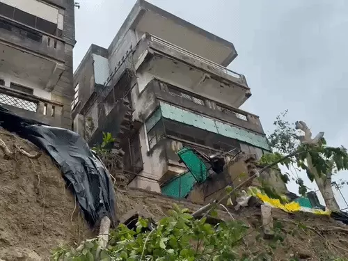 कानपुर के जाजमऊ में गंगा किनारे मिट्टी कटने से क्षतिग्रस्त अपार्टमेंट की बाउंड्री