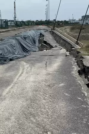 लखनऊ के इकाना स्टेडियम के पास सीजी सिटी में बारिश से धंसी निर्माणाधीन सड़क और सुरक्षा के लिए लगाए गए बैरियर।