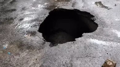 लखनऊ में आईटी चौराहे के पास सड़क धंसने के बाद बैरिकेडिंग किया गया गहरा गड्ढा