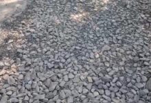 अंबेडकरनगर जिला मुख्यालय पर जिलाधिकारी कार्यालय के पास गड्ढों और बिखरी गिट्टियों वाली खराब सड़क।