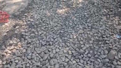 अंबेडकरनगर जिला मुख्यालय पर जिलाधिकारी कार्यालय के पास गड्ढों और बिखरी गिट्टियों वाली खराब सड़क।