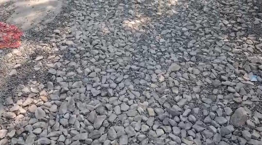 अंबेडकरनगर जिला मुख्यालय पर जिलाधिकारी कार्यालय के पास गड्ढों और बिखरी गिट्टियों वाली खराब सड़क।