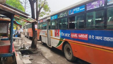 अकबरपुर बाजार में दुकानों के सामने खड़ी रोडवेज बसें