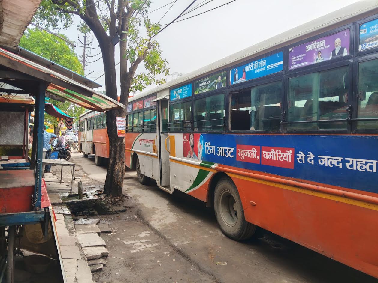 अकबरपुर बाजार में दुकानों के सामने खड़ी रोडवेज बसें