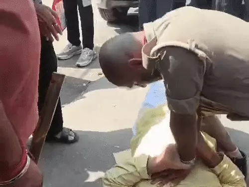 लखनऊ में सड़क पर अचानक गिर पड़े बुजुर्ग को CPR देकर मदद करते पुलिसकर्मी।